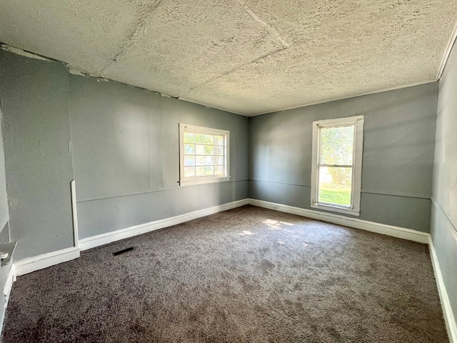 carpeted spare room with a textured ceiling