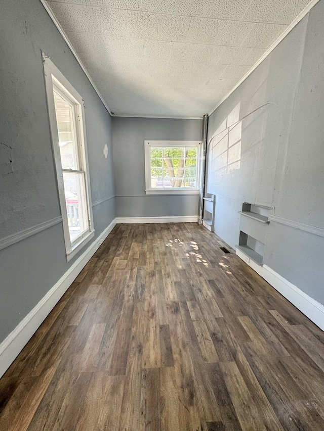 spare room with a textured ceiling, dark hardwood / wood-style floors, and ornamental molding