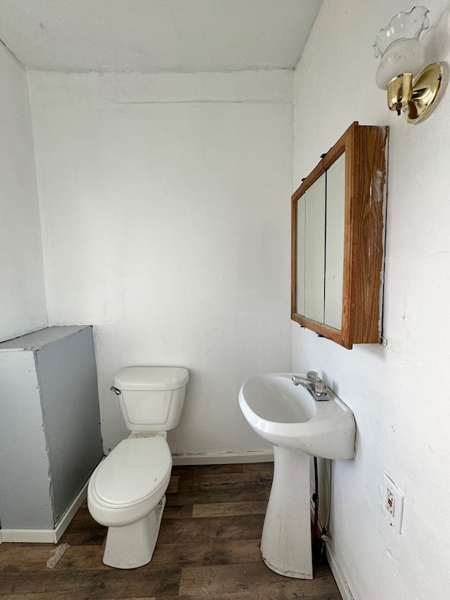 bathroom featuring wood-type flooring and toilet