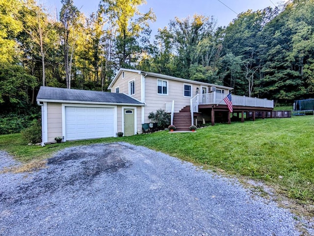 view of front of house featuring a front yard, an outbuilding, a garage, and a wooden deck