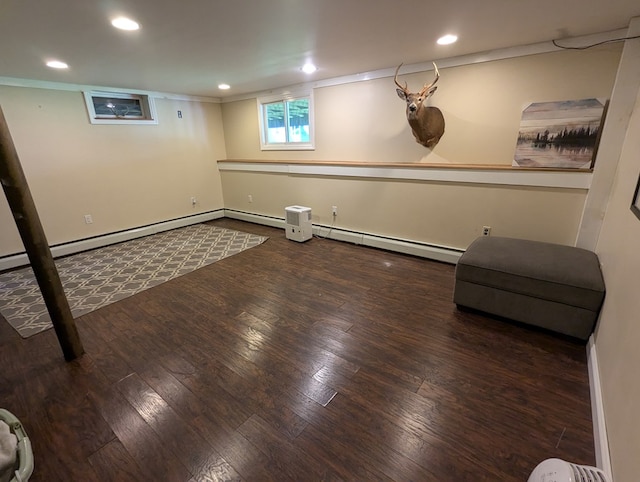 basement featuring wood-type flooring and a baseboard heating unit