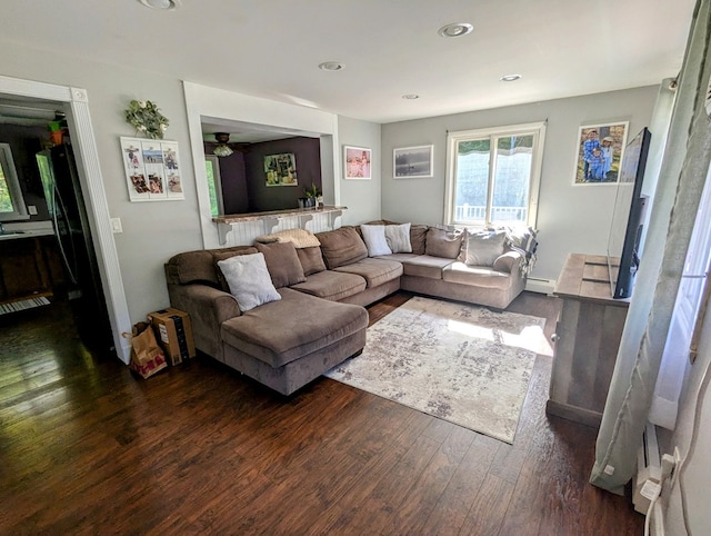 living room featuring a baseboard heating unit and dark hardwood / wood-style floors