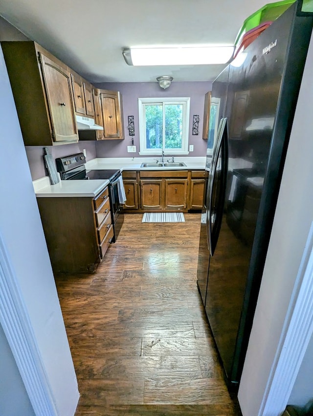 kitchen featuring sink, hardwood / wood-style flooring, and black appliances