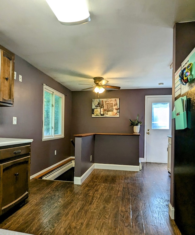 kitchen featuring dark wood-type flooring, ceiling fan, and baseboard heating