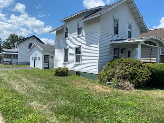 rear view of property featuring a lawn