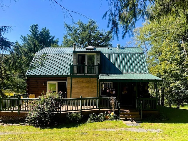 rear view of house featuring a lawn and a deck