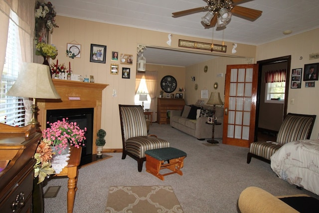 living room with ceiling fan, carpet, a healthy amount of sunlight, and ornamental molding