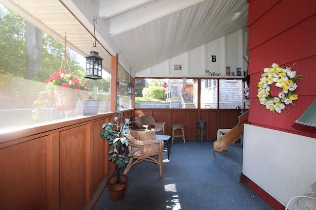 sunroom featuring vaulted ceiling with beams