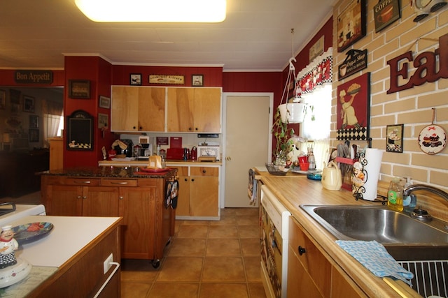 kitchen with crown molding, sink, and light tile patterned floors