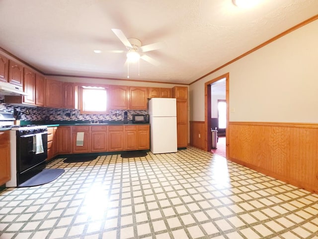 kitchen with black appliances, decorative backsplash, ceiling fan, ornamental molding, and range hood