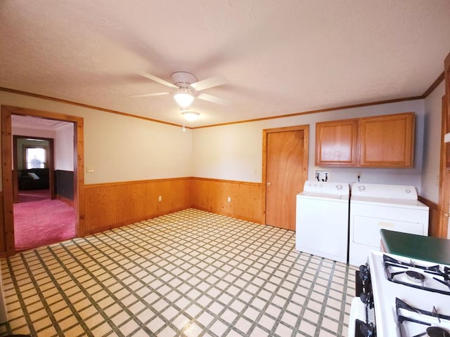 laundry area featuring ceiling fan, cabinets, washing machine and dryer, crown molding, and a textured ceiling