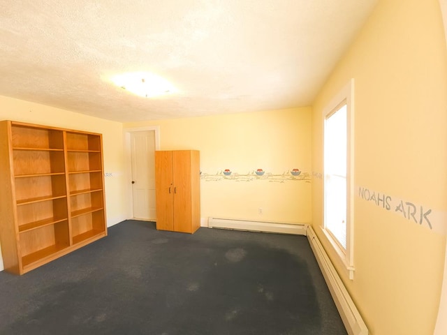 unfurnished room with carpet flooring, a textured ceiling, and a baseboard heating unit