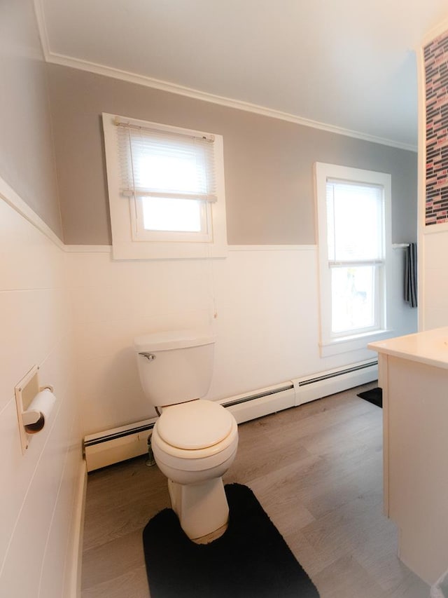 bathroom with plenty of natural light, wood-type flooring, and a baseboard heating unit