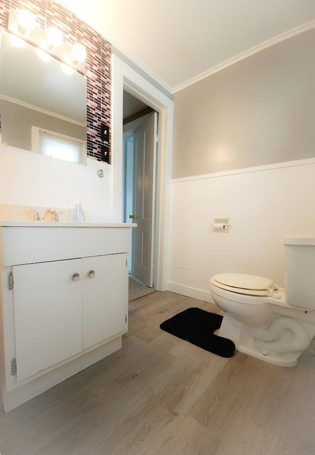 bathroom with hardwood / wood-style floors, vanity, ornamental molding, and toilet