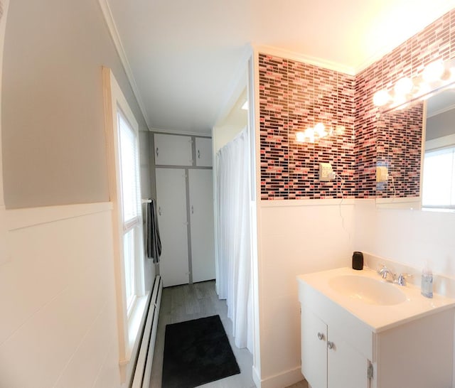 bathroom featuring hardwood / wood-style flooring, vanity, a baseboard heating unit, and ornamental molding