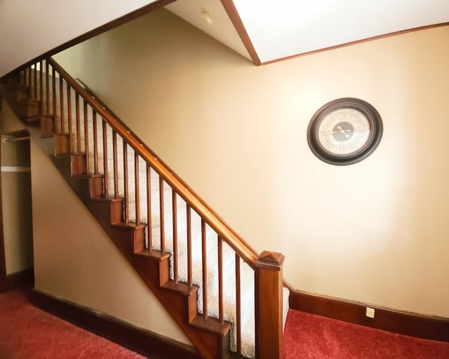 staircase featuring lofted ceiling and carpet floors