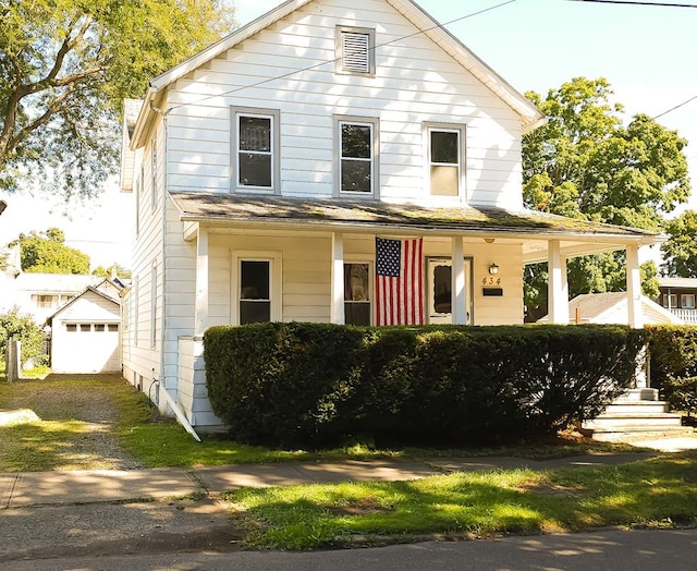 farmhouse featuring covered porch, an outdoor structure, and a garage