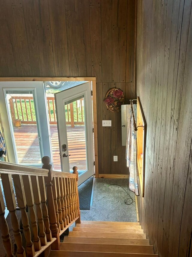 doorway to outside with wood walls