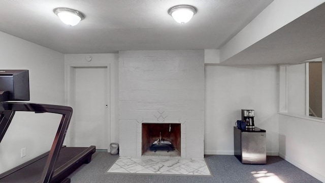 exercise room with light colored carpet and a fireplace