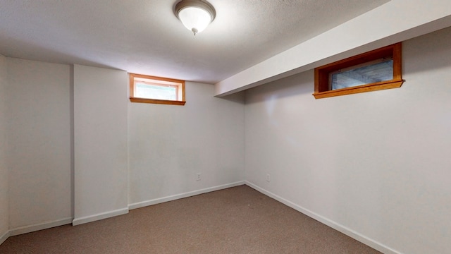 basement featuring a textured ceiling and carpet floors