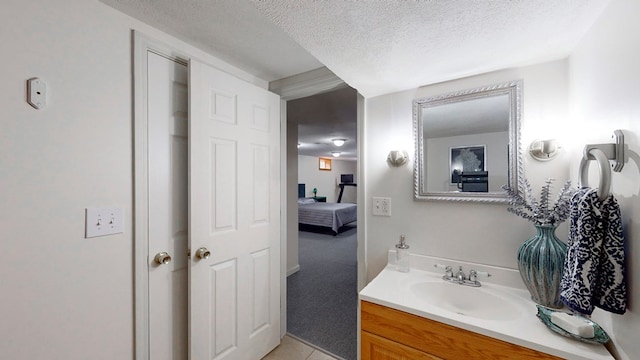 bathroom featuring tile patterned flooring, vanity, and a textured ceiling