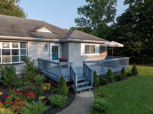 back of property with a yard and a deck