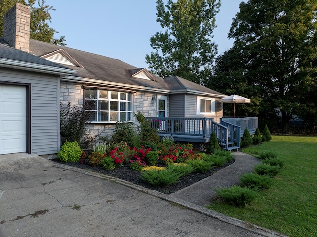 view of front facade with a deck and a front yard