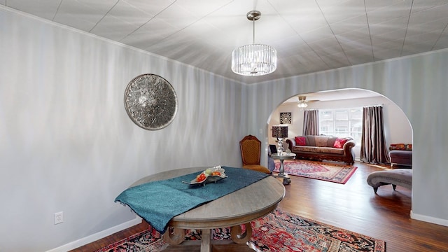 dining area featuring hardwood / wood-style floors, an inviting chandelier, and crown molding