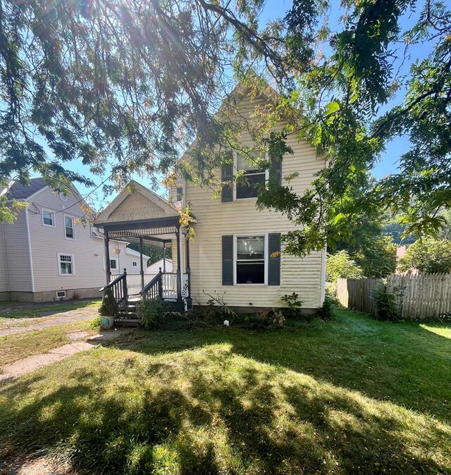 view of front of property with covered porch and a front yard