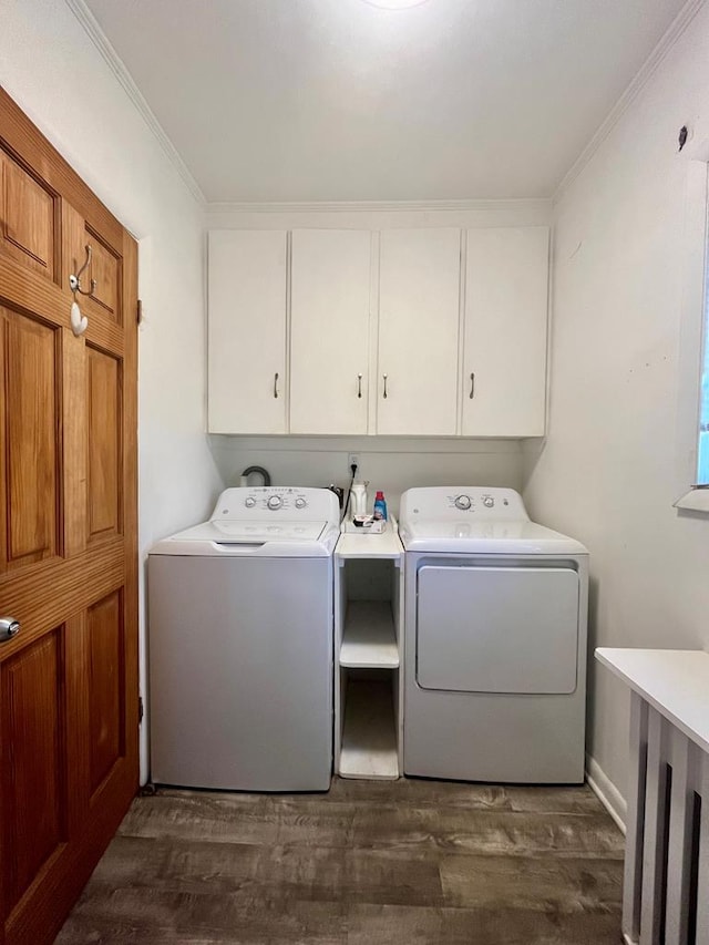 clothes washing area with ornamental molding, independent washer and dryer, dark hardwood / wood-style floors, and cabinets