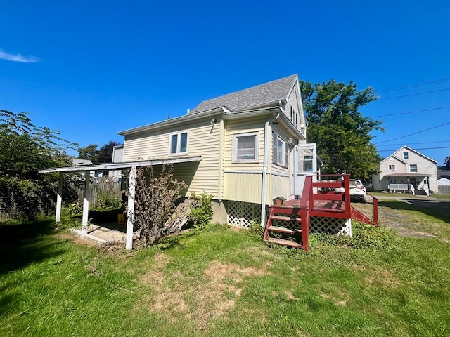 back of property featuring a deck and a lawn