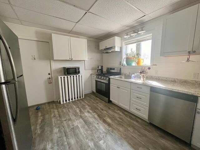 kitchen featuring white cabinetry, appliances with stainless steel finishes, and a drop ceiling