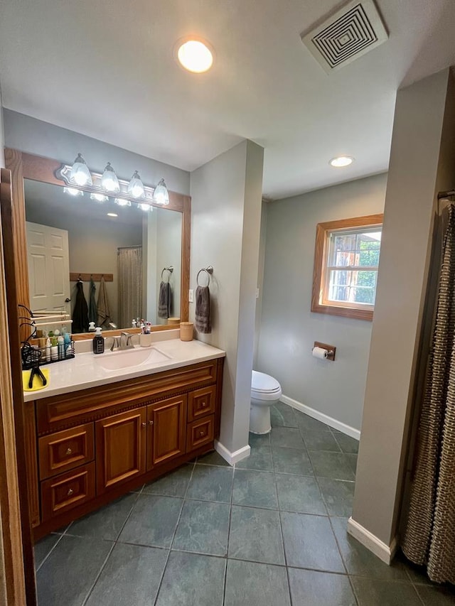 bathroom featuring toilet, vanity, and tile patterned floors