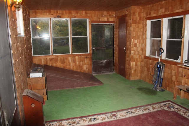 interior space featuring carpet floors, wooden ceiling, and wood walls