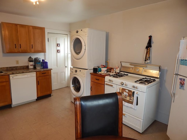 kitchen with stacked washer / drying machine and white appliances