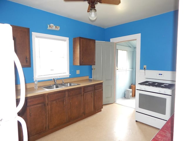 kitchen featuring ceiling fan, sink, and white appliances