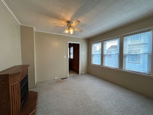 unfurnished living room with crown molding, ceiling fan, and light carpet