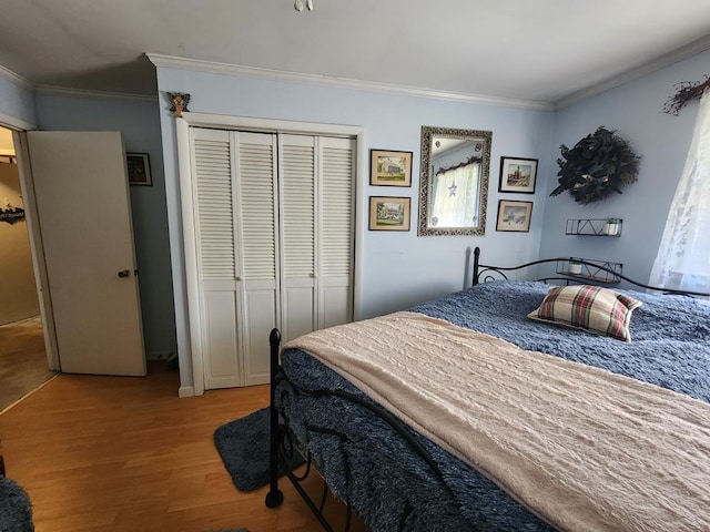 bedroom with wood-type flooring, ornamental molding, and a closet