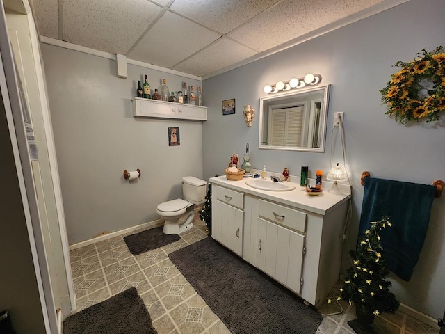 bathroom featuring vanity, a paneled ceiling, toilet, and tile patterned floors