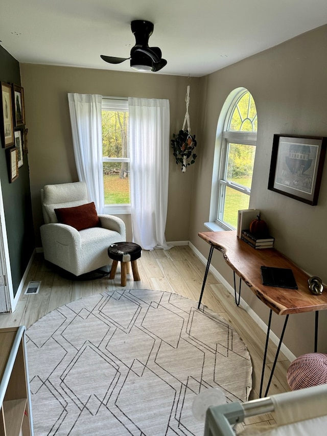 living area with ceiling fan and light wood-type flooring