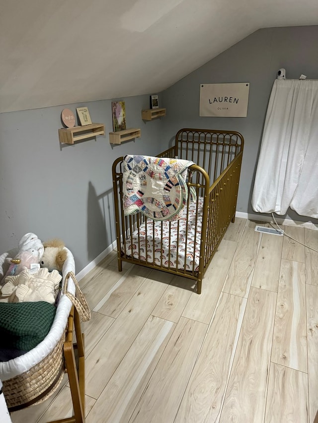 bedroom featuring hardwood / wood-style floors and lofted ceiling