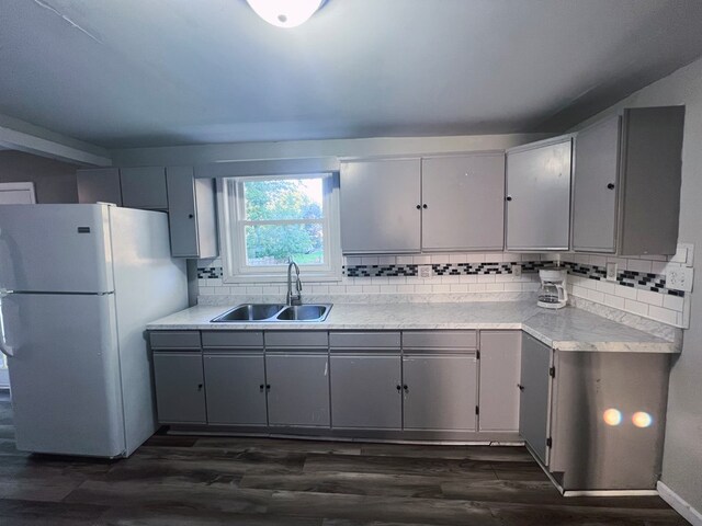 kitchen with sink, dark hardwood / wood-style floors, gray cabinets, and white fridge