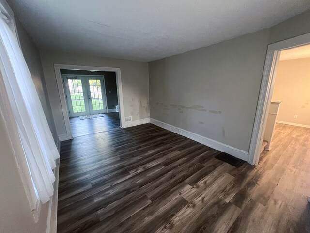 empty room featuring dark wood-type flooring and french doors