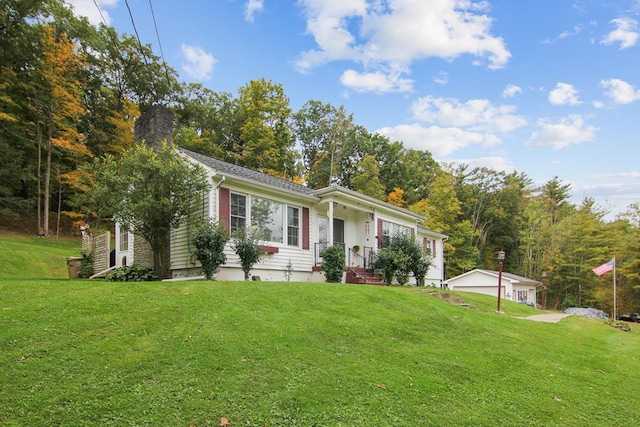 ranch-style home featuring a garage, an outbuilding, and a front lawn