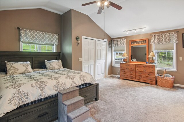 carpeted bedroom with rail lighting, vaulted ceiling, ceiling fan, cooling unit, and a closet