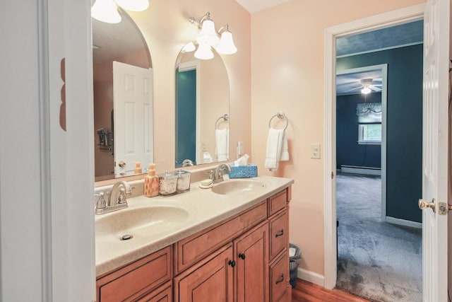 bathroom with hardwood / wood-style floors, vanity, and a baseboard radiator