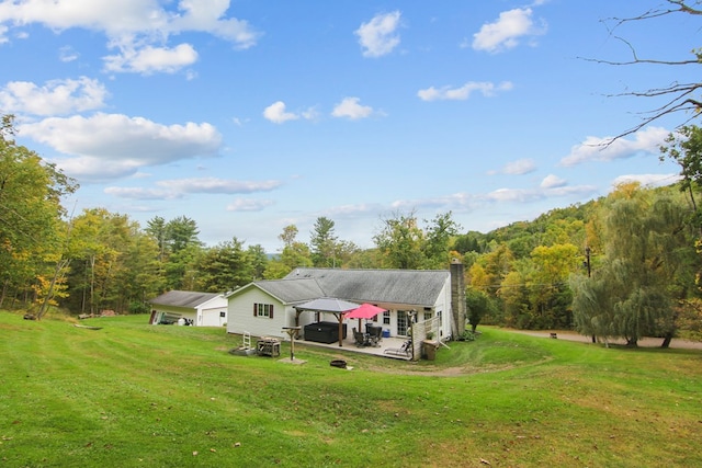 rear view of property featuring a gazebo, a yard, and a patio