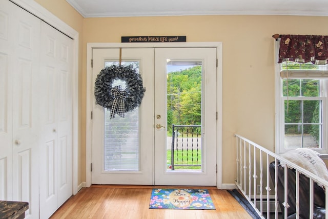 doorway featuring light hardwood / wood-style flooring, french doors, and ornamental molding