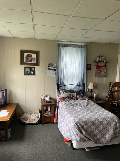 bedroom featuring a drop ceiling and carpet floors