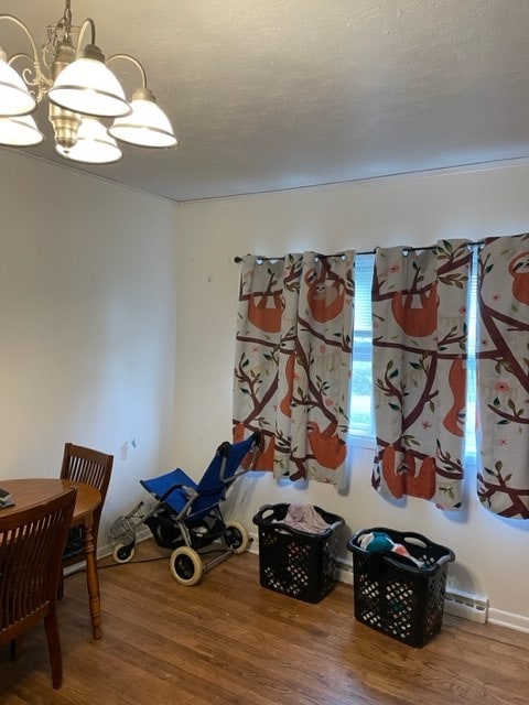 game room featuring a notable chandelier, a baseboard radiator, and hardwood / wood-style floors